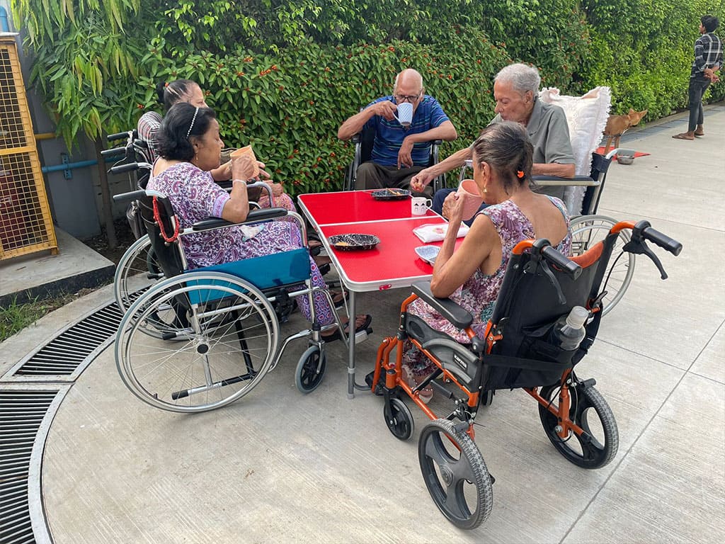 Residents and caregivers relaxing together in the ARCHON garden